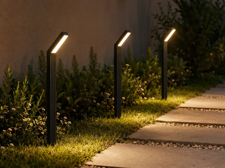 Tre lampade solari da giardino Lumière posizionate lungo un percorso esterno